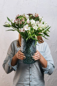 Midsection of woman holding bouquet