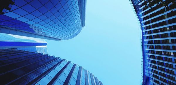 Low angle view of modern buildings against clear blue sky