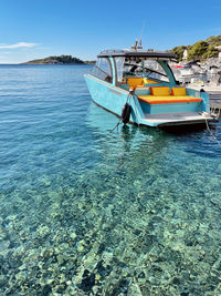 Boat moored on beach against sky