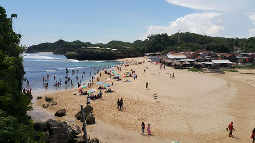 People at beach against sky