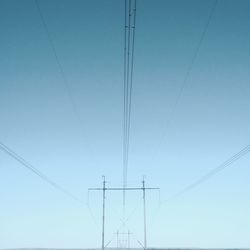 Low angle view of overhead cable car against clear sky