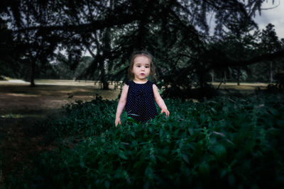 Girl standing by plants in park
