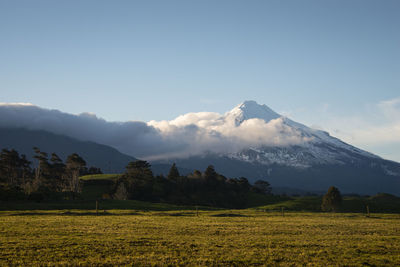 Scenic view of field and mountains against sky