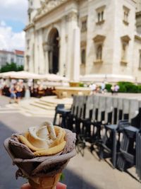 Close-up of ice cream against buildings in city