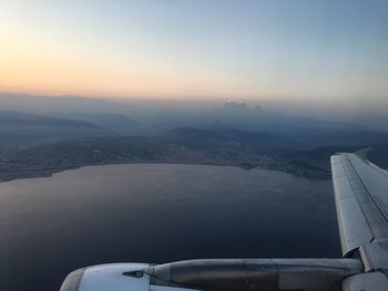 Airplane flying over landscape against sky