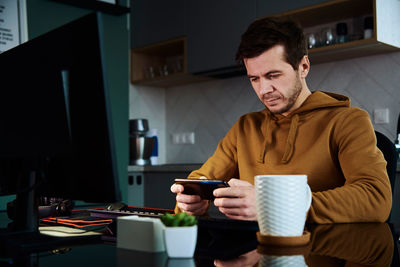 Man play game on smartphone while working at home warkplace