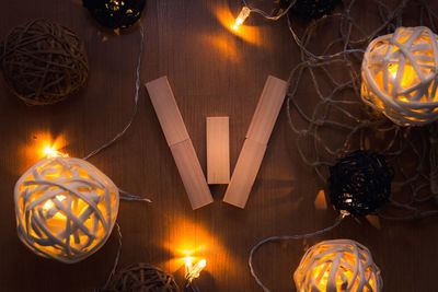 Directly above shot of letter w blocks and illuminated lights on wooden table