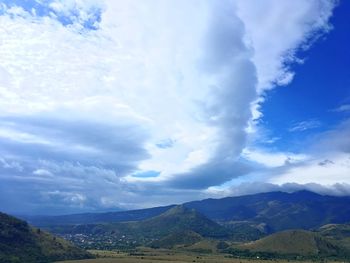 View of countryside landscape against cloudy sky