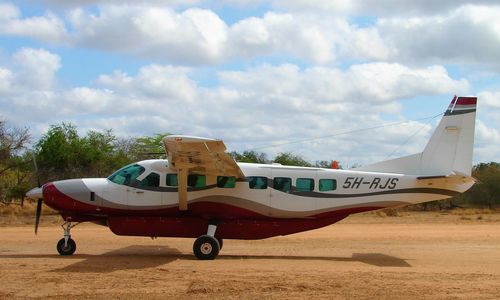 Airplane on airport runway against sky