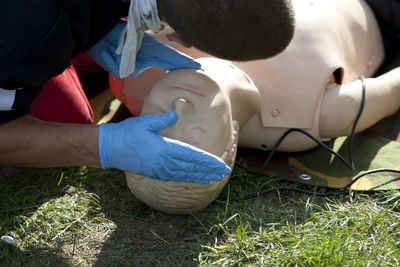 Paramedic examining cpr dummy on field