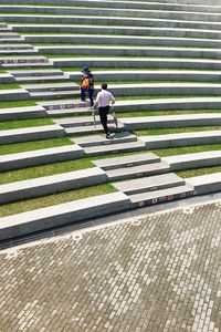 High angle view of men walking on cobblestone