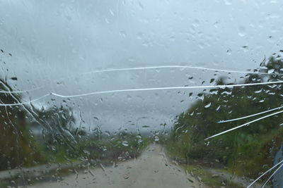 Close-up of wet glass window during rainy season