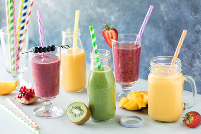 Delicious fruit smoothies surrounded by pieces of fresh fruit.