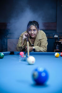 Portrait of woman playing pool