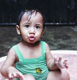 Cute baby girl sitting in bathtub at yard