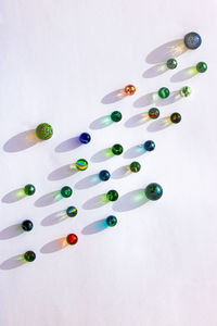 High angle view of colored marbles on white background