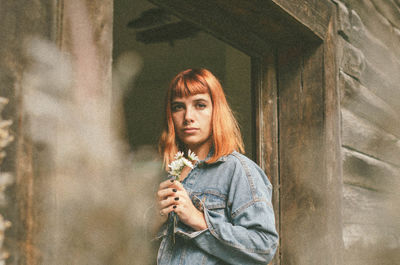 Young woman standing against wall