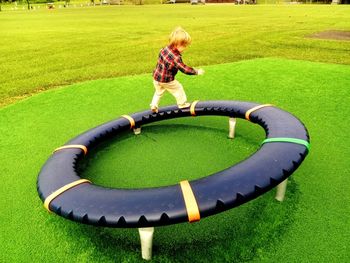 Boy playing on play equipment at park