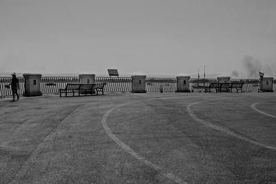 Empty road leading towards building against sky