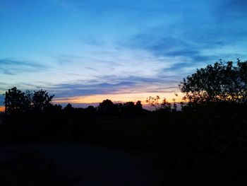 Scenic view of silhouette trees against sky at sunset