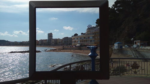 Cityscape by sea against sky