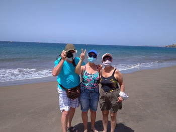 People standing on beach against sea