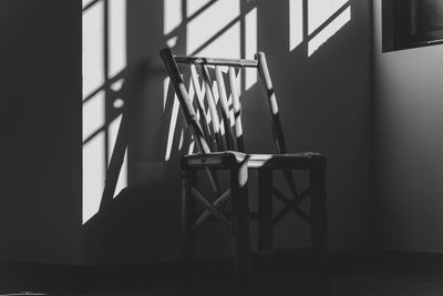 Empty chair by table against wall at home