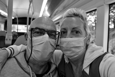 Close-up portrait of couple wearing masks in bus