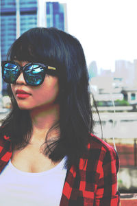 Close-up portrait of young woman wearing sunglasses