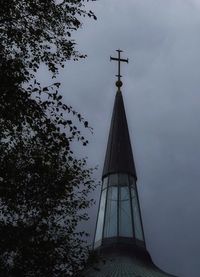 Low angle view of tower by building against sky