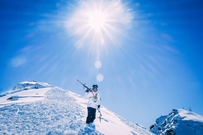 Man skiing on snowcapped mountain against sky