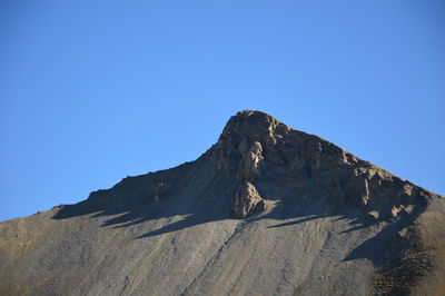 Low angle view of mountain against blue sky