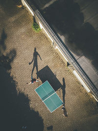 Mature man with daughter playing table tennis at back yard