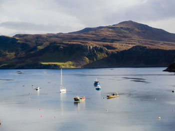 Boats moored on lake against sky