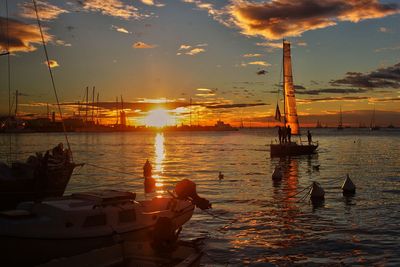 Boats in sea at sunset
