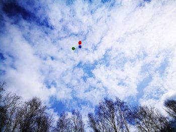 Low angle view of paragliding against blue sky