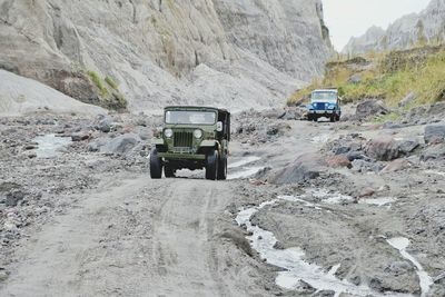 Off-road vehicles moving on dirt road at desert