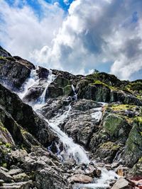 Low angle view of waterfall against sky