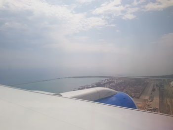 Airplane flying over sea against sky