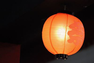 Low angle view of illuminated lantern against sky at night