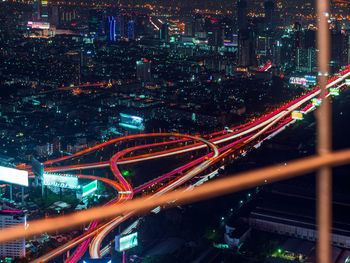 High angle view of light trails on street amidst buildings at night