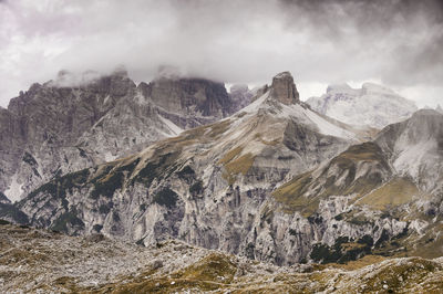 High angle shot of rocky mountains against clouds