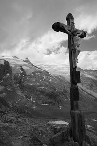 Cross on land against sky