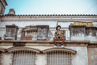 Portrait of woman standing against building