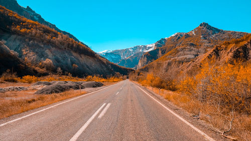 Road amidst rocky mountains against sky