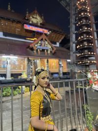 Portrait of young woman standing in city