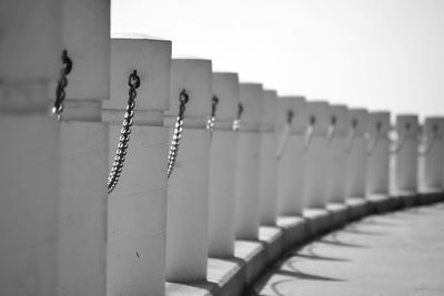 Close-up of metal fence against white wall