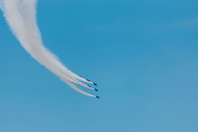 Low angle view of airplane flying against blue sky