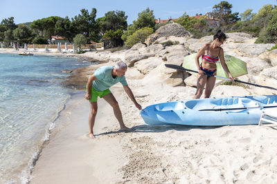 Mature couple pulling out kayak to the sea. leisure activities on the sea.