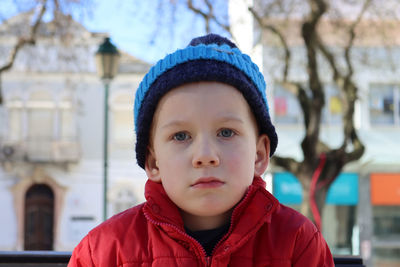 Portrait of a pensive boy in a  blue hat. a detached six-year-old boy looks into the distance.